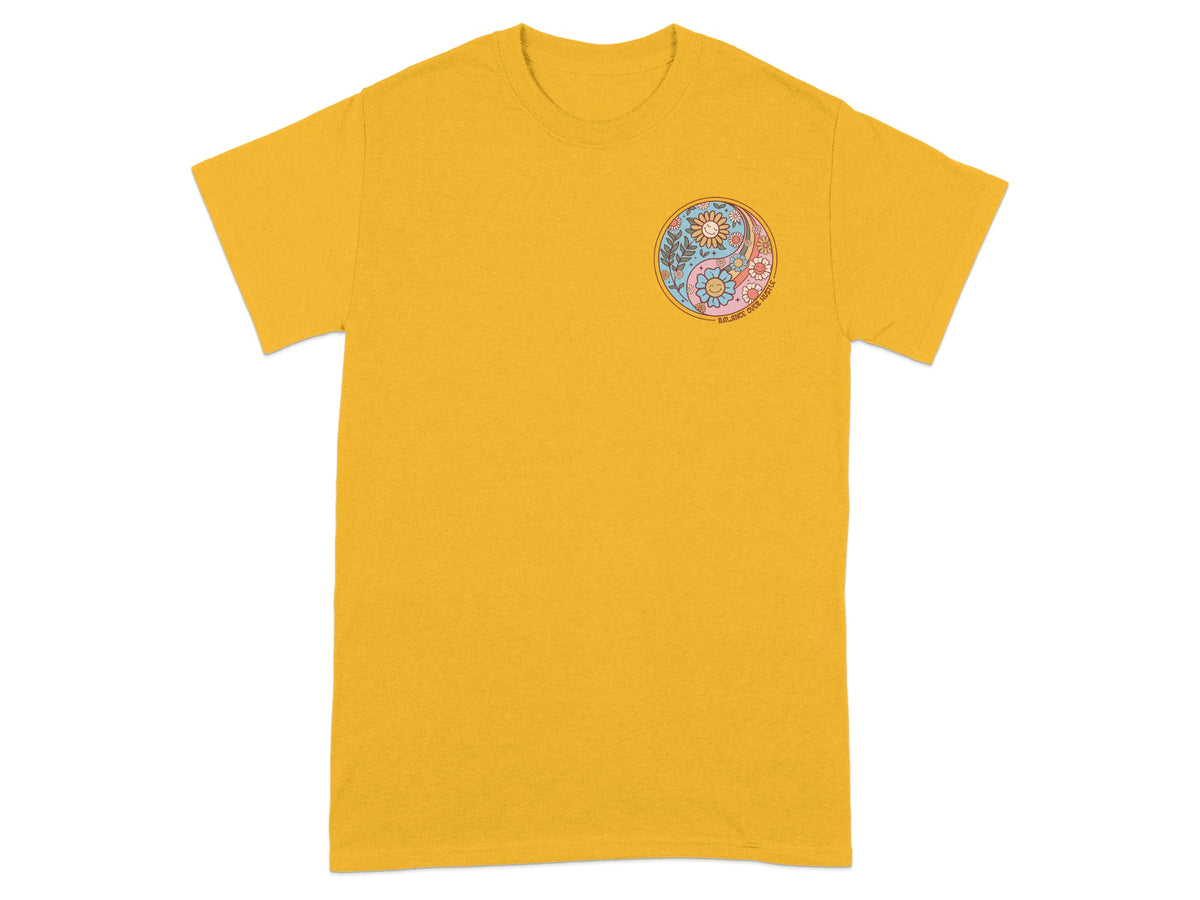 Yellow t-shirt with a floral yin yang graphic and "Balance Over Hustle" text.