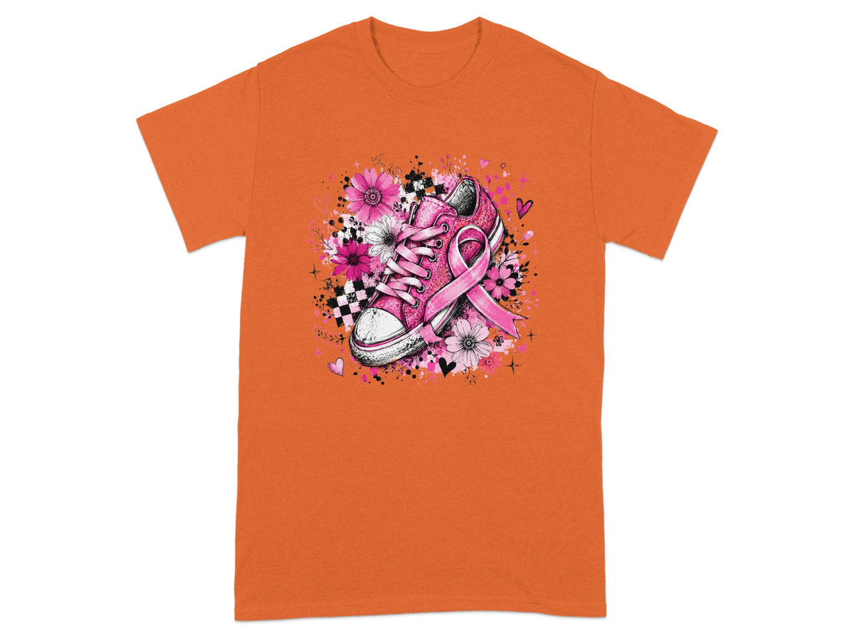 Pink sneaker with breast cancer ribbon and floral design on orange t-shirt.