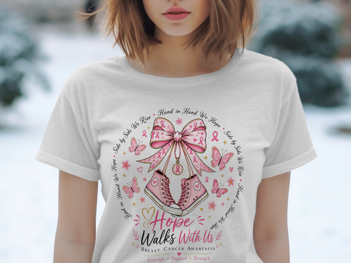 White t-shirt with breast cancer awareness graphic featuring pink sneakers, a bow, butterflies, and text.