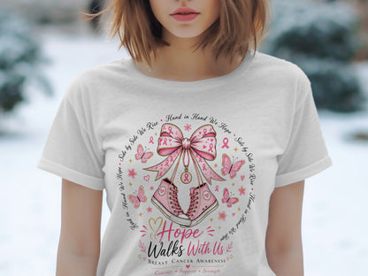 White t-shirt with breast cancer awareness graphic featuring pink sneakers, a bow, butterflies, and text.