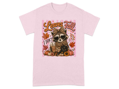 Pink t-shirt with raccoon, black cat, coffee cup, pumpkins, and "Leaves Fall" text.