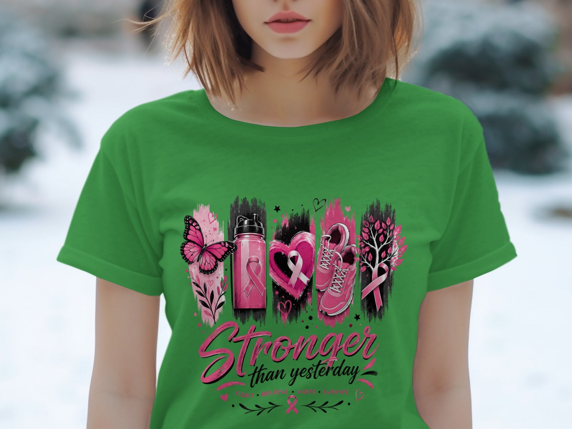 Green t-shirt with "Stronger than yesterday" text and breast cancer awareness graphics.