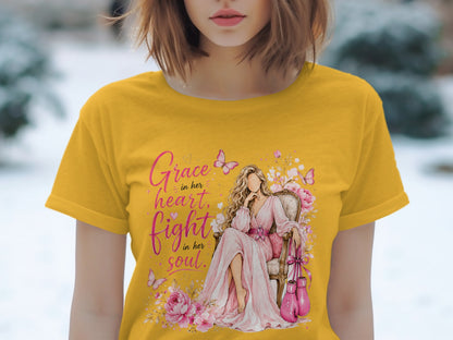 Yellow t-shirt with "Grace in her heart, fight in her soul" and a seated woman with boxing gloves.