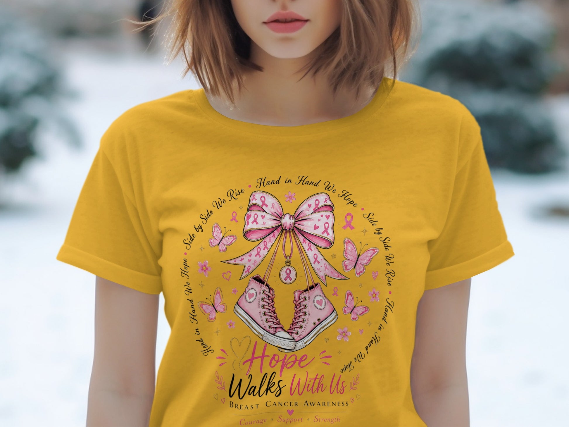 Yellow t-shirt with breast cancer awareness design featuring pink sneakers, butterflies, and ribbon.