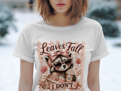 T-shirt graphic: Raccoon in sunglasses, holding coffee, with text "Leaves Fall I Don't".