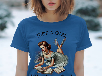 Blue t-shirt with "JUST A GIRL" text and a pin-up style woman reading books.