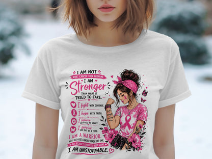 Woman wearing a white t-shirt with pink cancer awareness text and graphics.