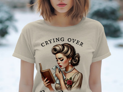 T-shirt with distressed crying woman reading a book and text "CRYING OVER"