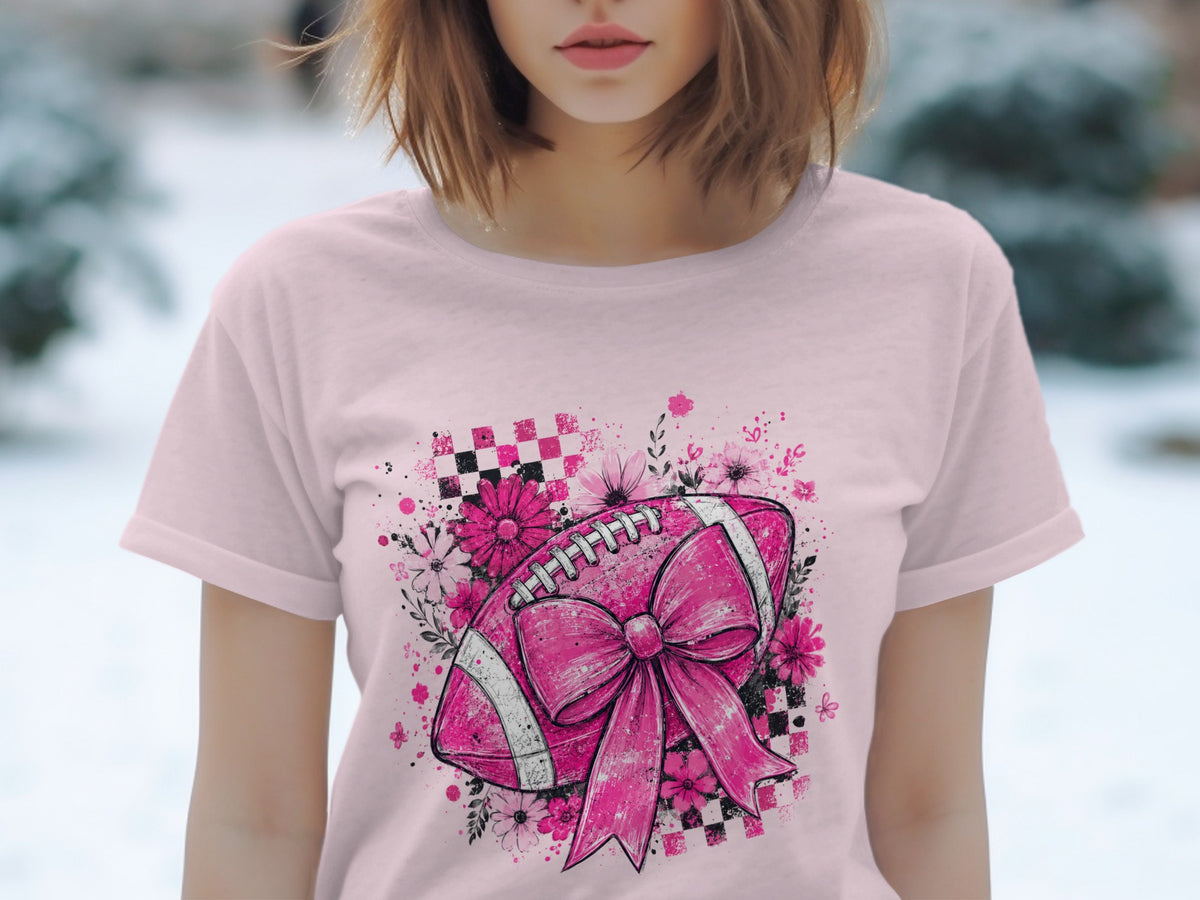 Pink t-shirt with a pink football graphic featuring a large bow and floral elements.