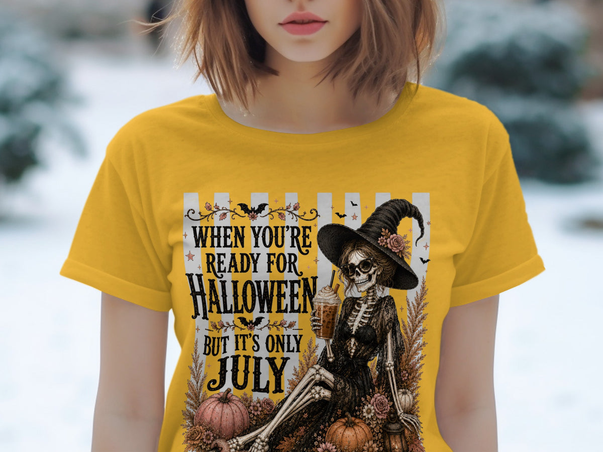Skeleton witch with drink, pumpkins, and text "When You're Ready for Halloween But It's Only July."