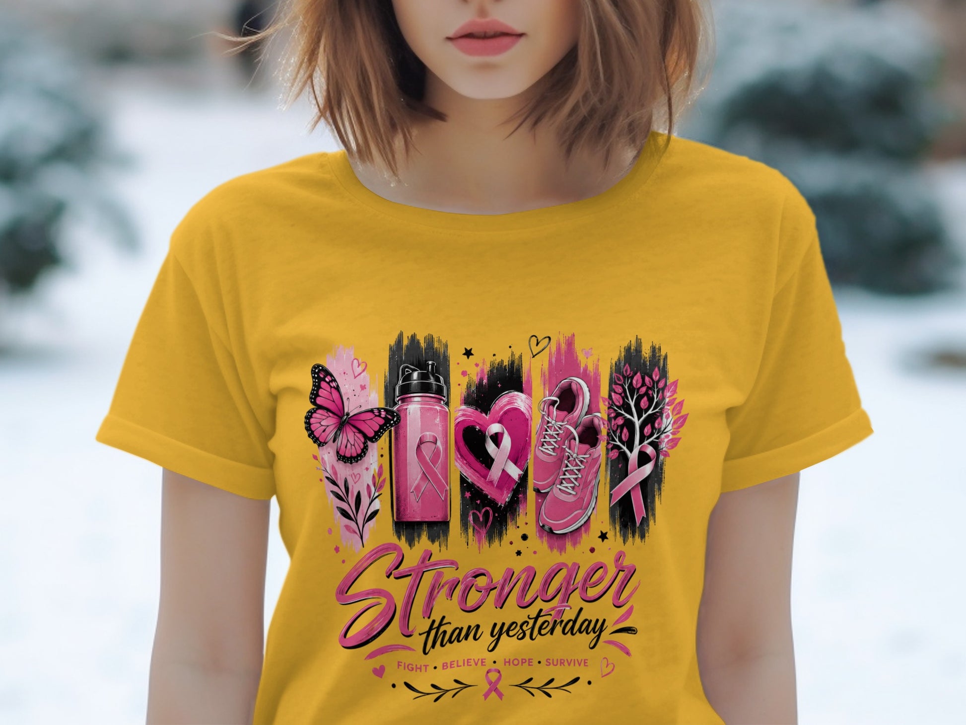 Yellow t-shirt with "Stronger than yesterday" and breast cancer awareness graphics.