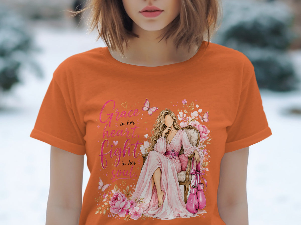 Orange t-shirt graphic with woman, pink boxing gloves, and text "Grace in her heart, fight in her soul."