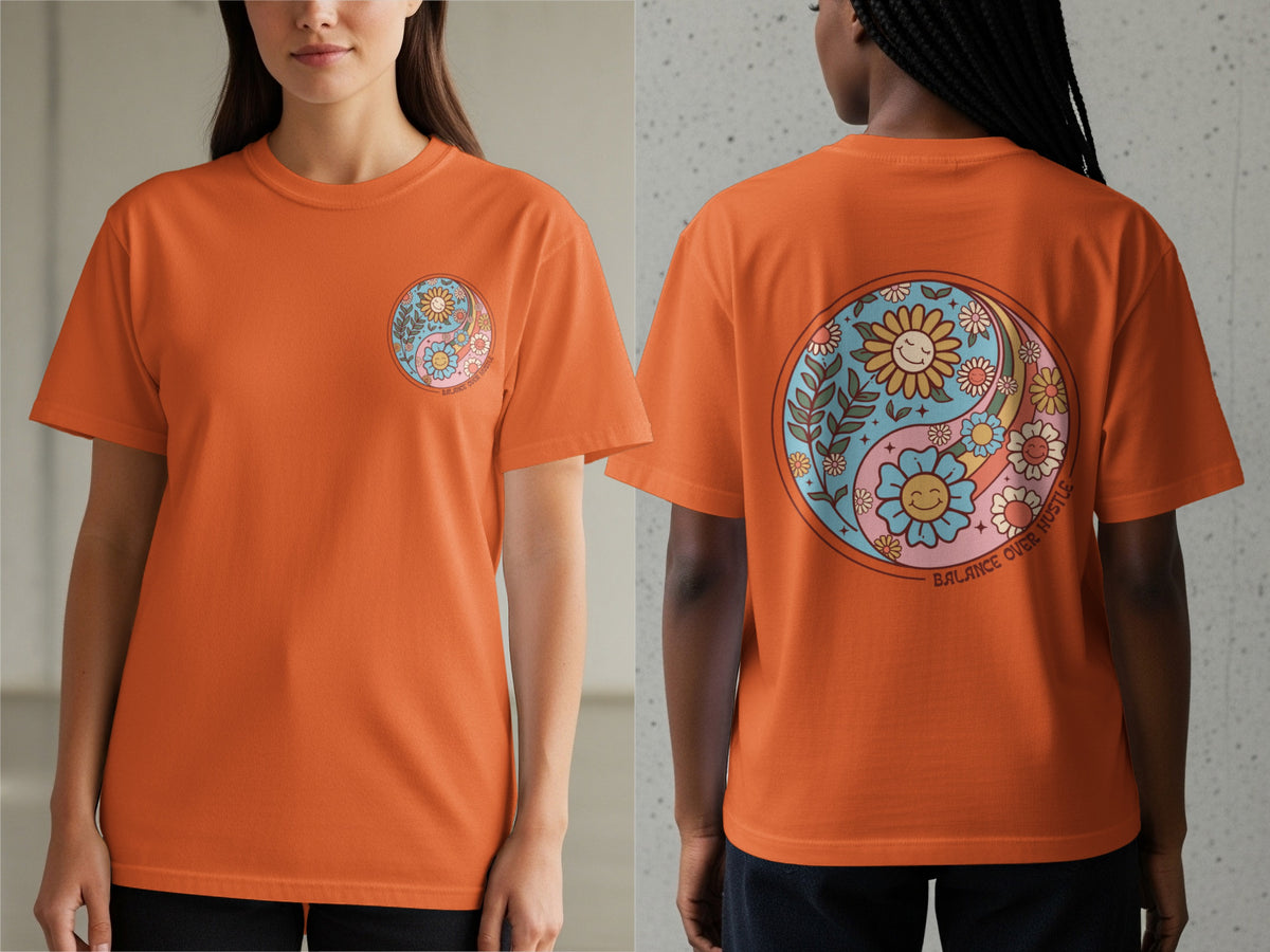 Orange t-shirt with yin yang design featuring smiling flowers and text "BALANCE OVER HUSTLE".