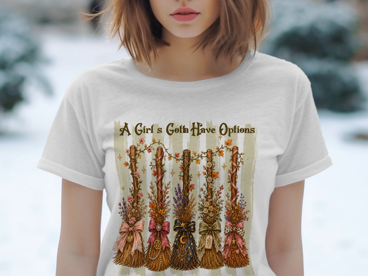 T-shirt with five decorative brooms, text "A Girl's Gotta Have Options."