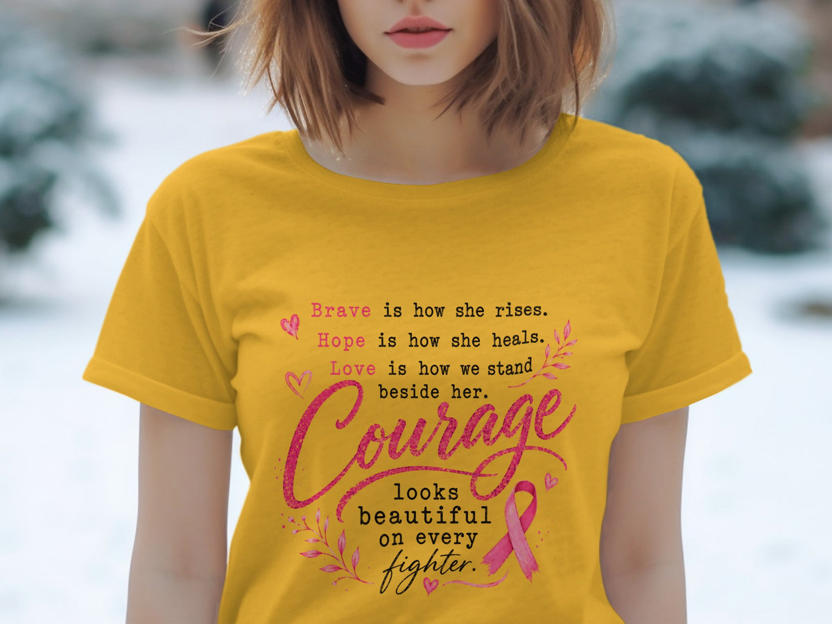 Yellow t-shirt with text: Brave is how she rises, Hope is how she heals, Love is how we stand beside her. Courage looks beautiful on every fighter.