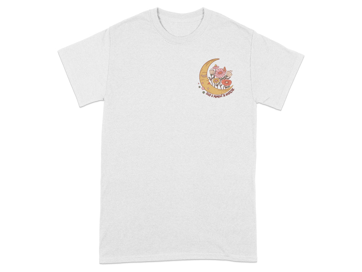 White t-shirt with a crescent moon and flowers graphic saying "Take a moment to breathe."