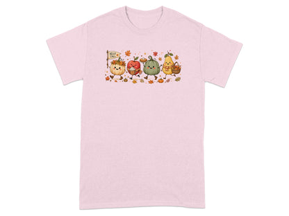 Fall-themed cartoon fruits and vegetables parade across a pink t-shirt.