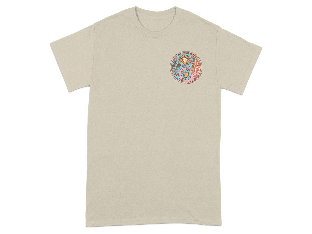 T-shirt with circular yin-yang design featuring flowers, suns, and text.