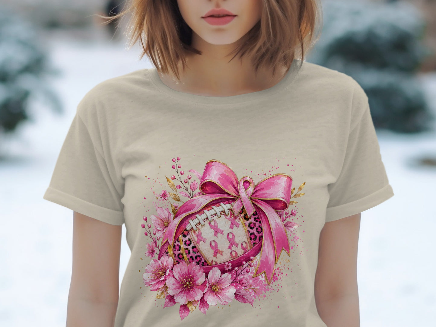 T-shirt with a football design featuring pink ribbons and floral accents.