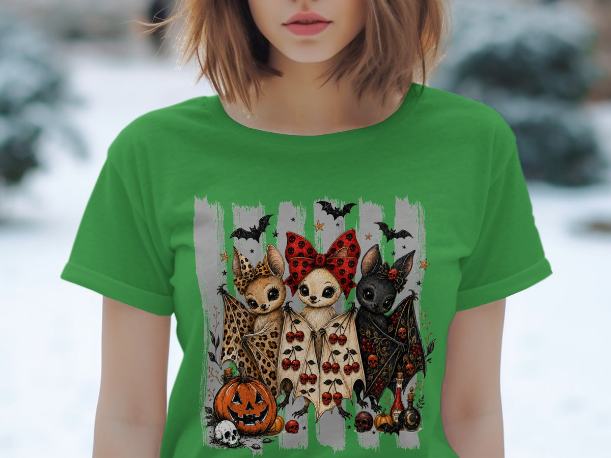 Green t-shirt featuring three cute bats with Halloween motifs and a jack-o'-lantern.