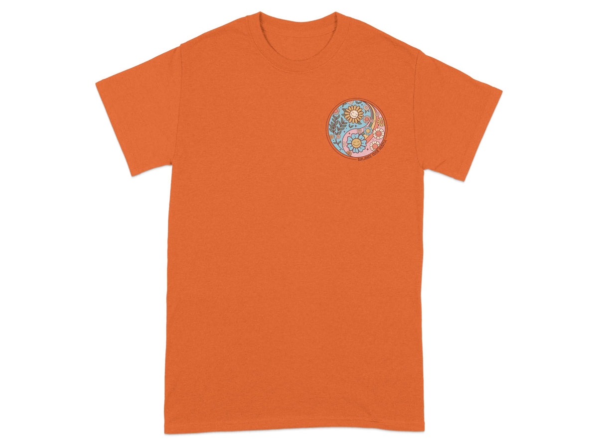 Orange t-shirt with a yin-yang symbol featuring flowers and smiling suns.