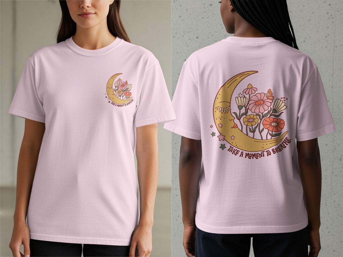 Pink t-shirt with a crescent moon, flowers, and the text "Take a moment to breathe".