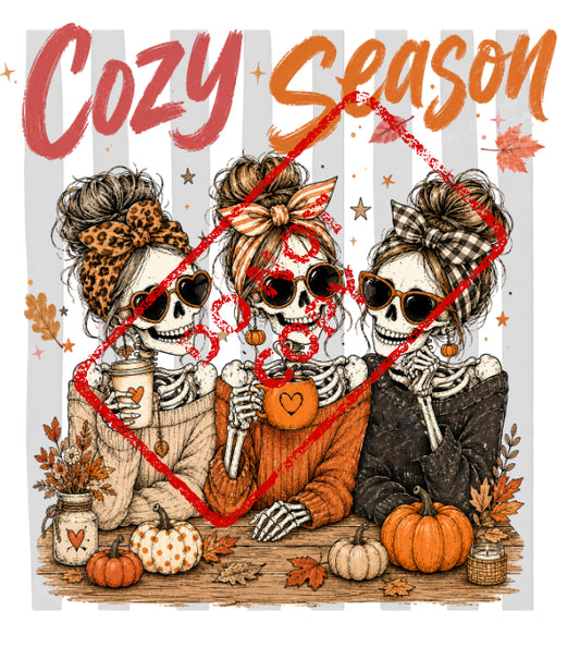 Three skeletons with messy buns and sunglasses hold coffee mugs, with "Cozy Season" text above.