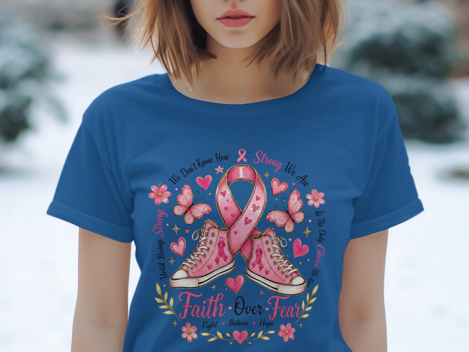 Pink ribbon and sneakers with "Faith Over Fear" text on a blue t-shirt.