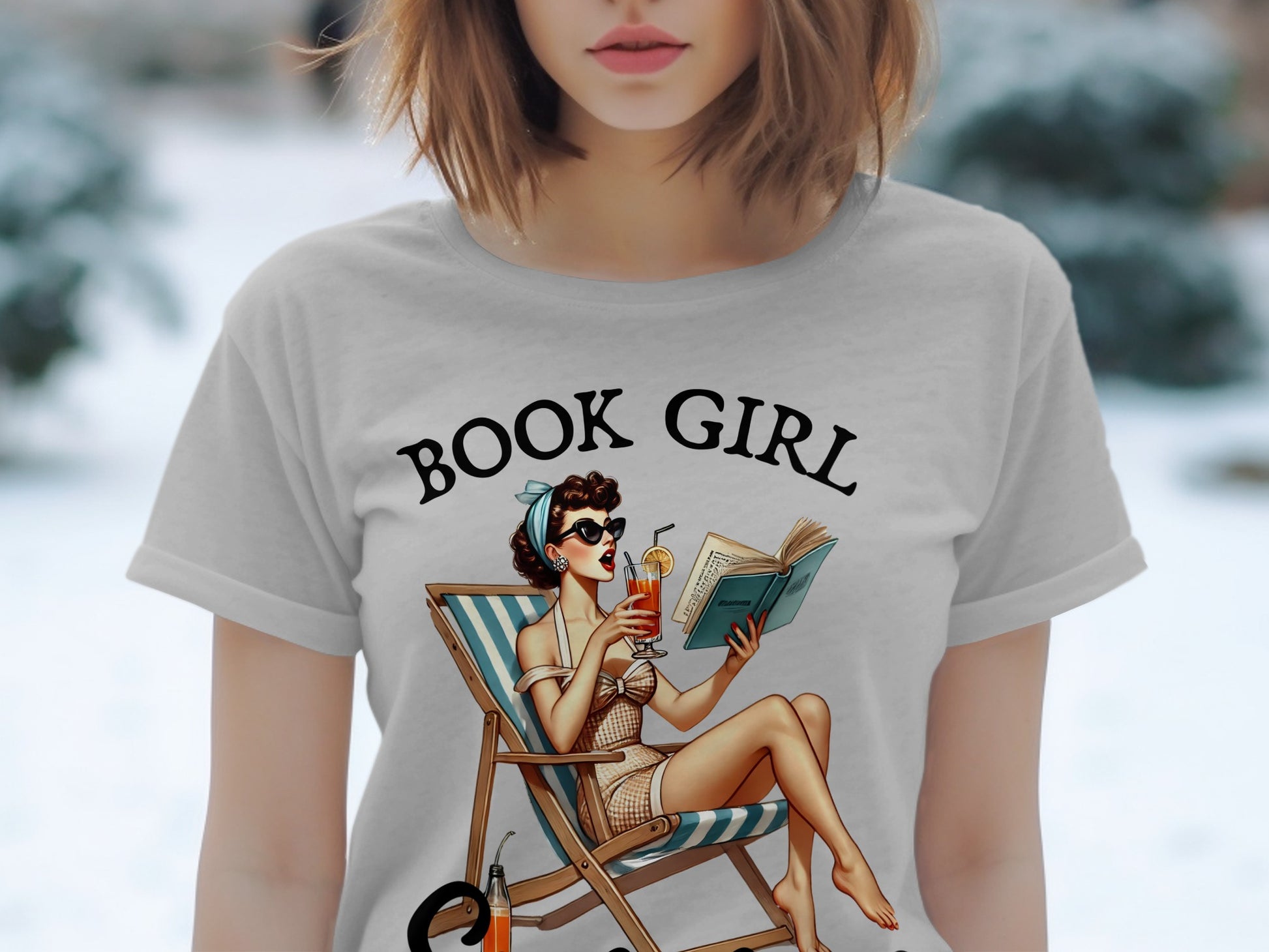 T-shirt graphic with "BOOK GIRL" text and retro pin-up reading on a deck chair.