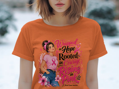 Orange t-shirt with "Wrapped in Hope Rooted in Courage Rising in Pink" text and breast cancer awareness ribbon.