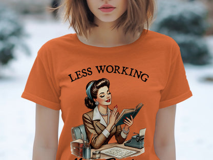 Orange t-shirt with "LESS WORKING" text and vintage illustration of woman reading.
