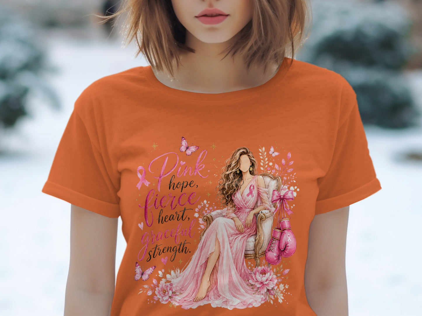 Orange t-shirt with "Pink hope, fierce heart, graceful strength" and breast cancer ribbon graphics.