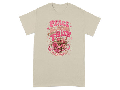T-shirt with "Peace Blooms Through Faith Held in His Mercy" text and floral cross design.