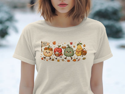 Animated pumpkin, apple, pumpkin, and pear with "HELLO FALL" flag on beige t-shirt.