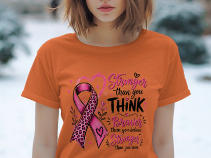 Orange t-shirt with pink ribbon and text: "Stronger than you THINK, Braver than you believe, Stronger than you seem".