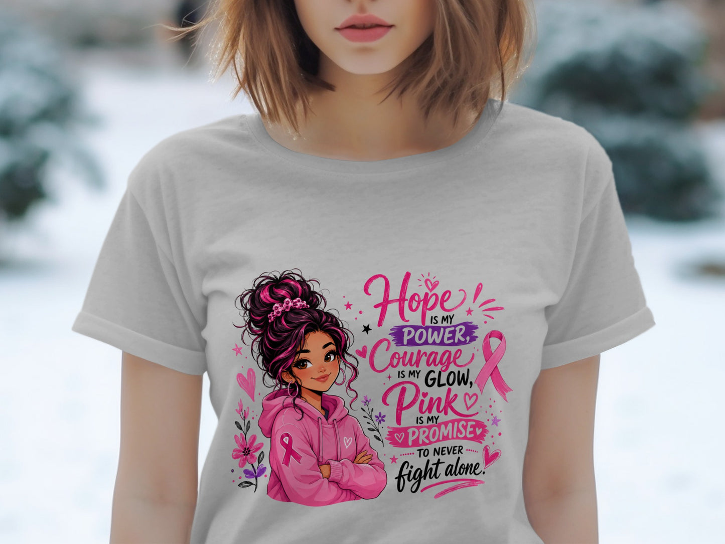 Woman in grey t-shirt with "Hope is my power, Courage is my glow, Pink is my promise to never fight alone" text and illustration.