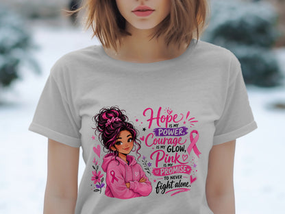 Woman in grey t-shirt with "Hope is my power, Courage is my glow, Pink is my promise to never fight alone" text and illustration.