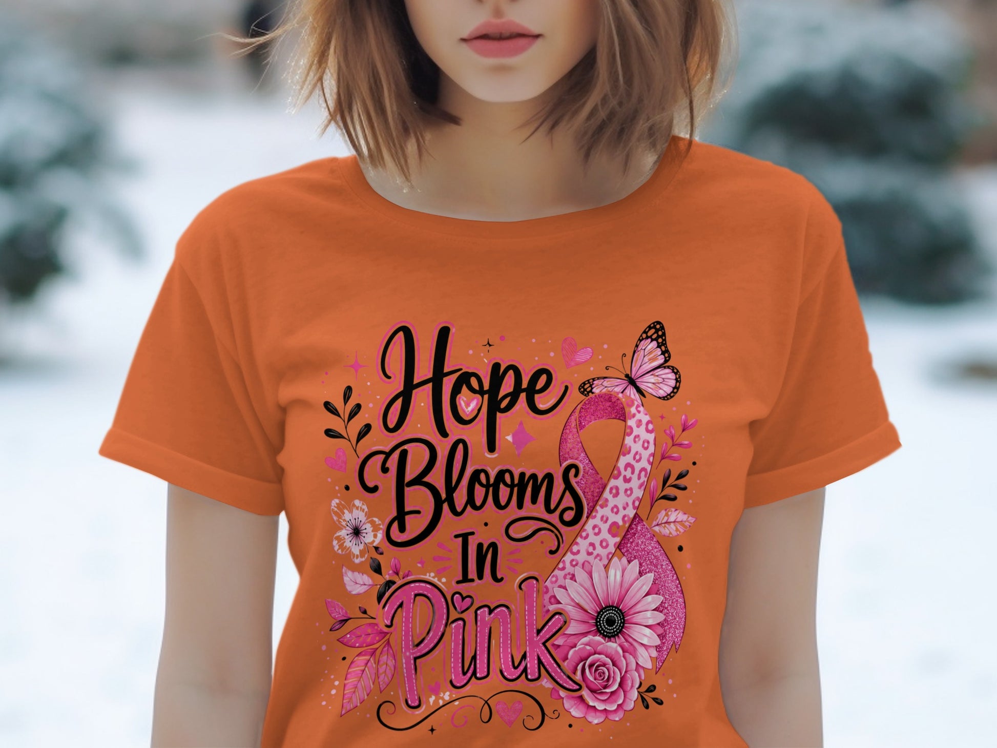 Orange t-shirt with "Hope Blooms In Pink" text and a pink ribbon with flowers and a butterfly.