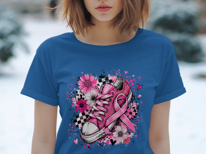 Pink sneaker with flowers and breast cancer awareness ribbon design on blue t-shirt.