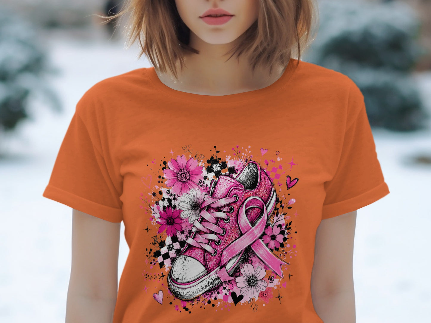 Orange t-shirt with pink glitter sneaker, flowers, and breast cancer ribbon.