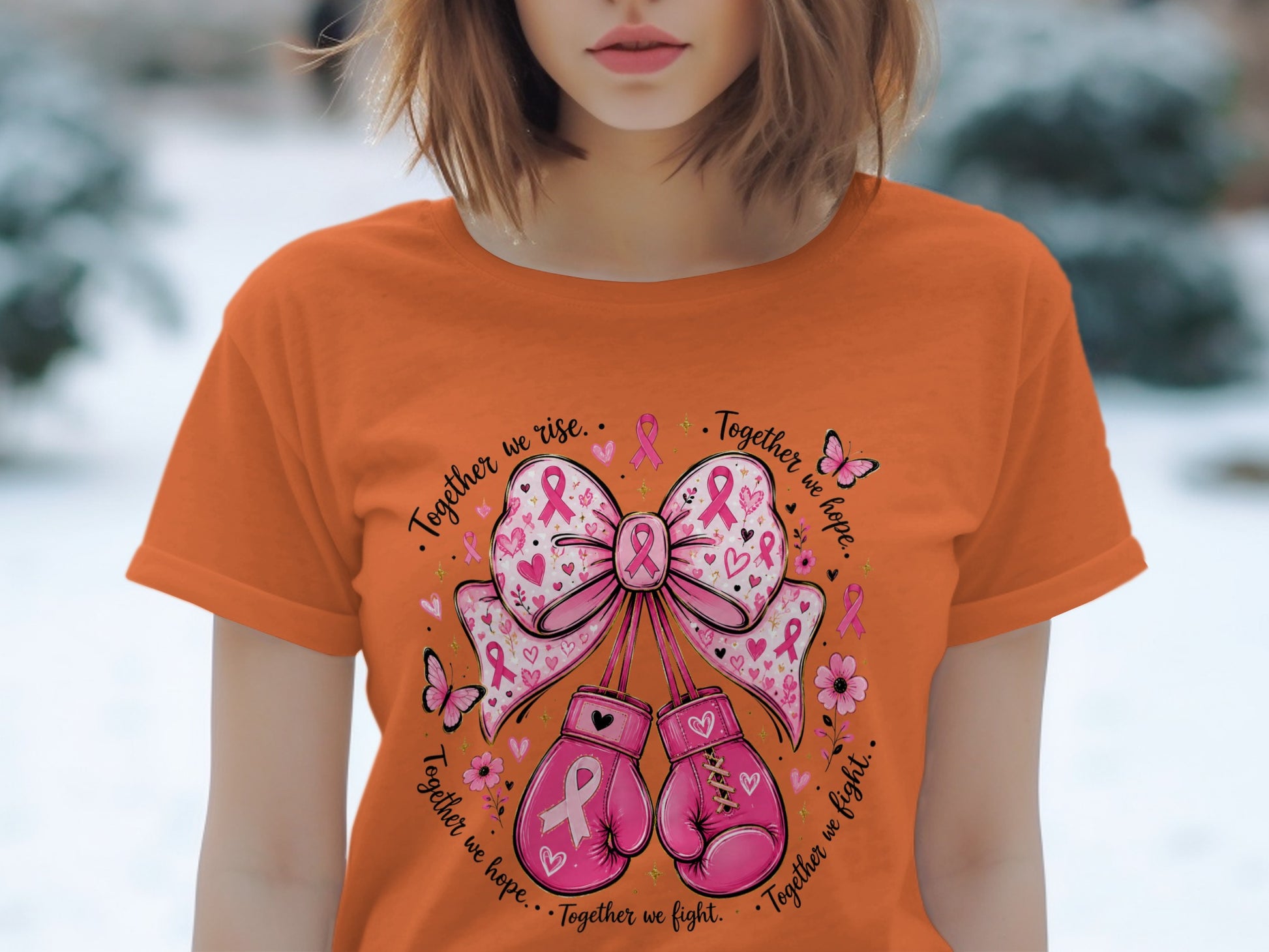 Orange t-shirt with pink boxing gloves and bow, featuring breast cancer awareness ribbons and the text "Together we rise. Together we hope. Together we fight."