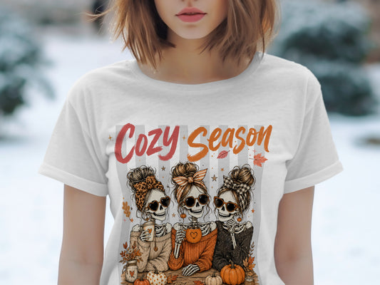 Three skeletons with heart sunglasses, messy buns, and cozy sweaters, text "Cozy Season".