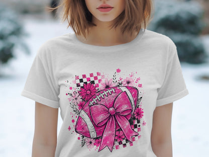 Pink football with bow, flowers, and checkered pattern on white t-shirt.