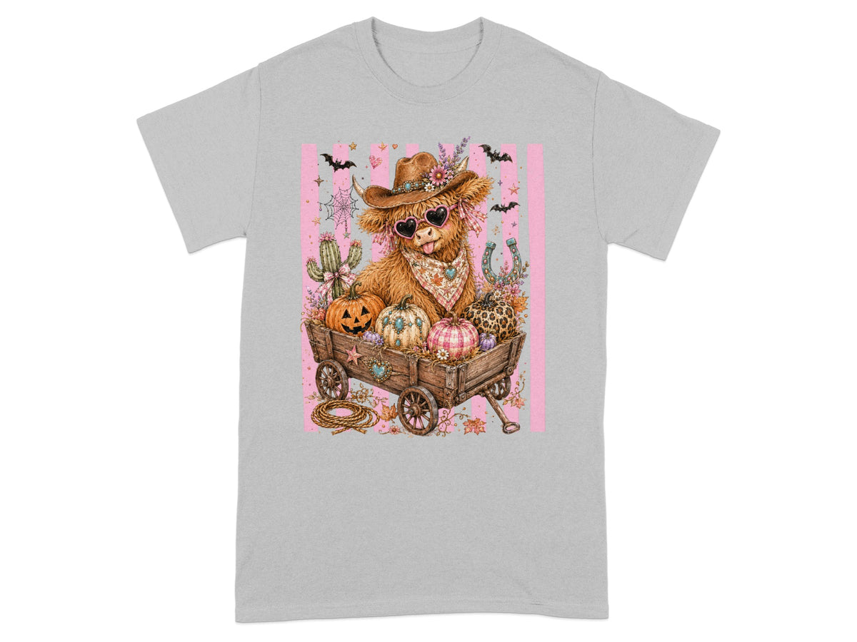 Cow wearing cowboy hat and heart sunglasses sits in wagon with pumpkins and spooky Halloween decor.