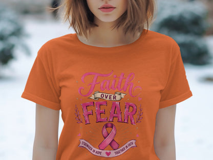 Orange t-shirt with pink text "Faith Over Fear" and a pink ribbon.