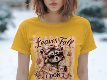 Yellow t-shirt with a graphic of a raccoon holding a coffee cup, text "Leaves Fall I DON'T".