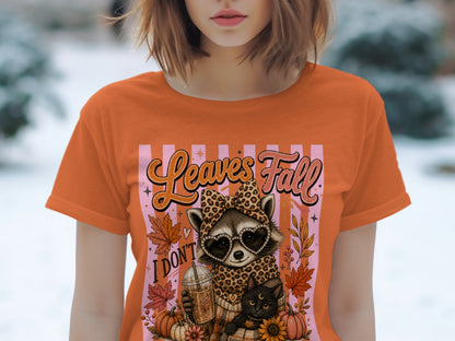 Orange t-shirt with raccoon, cat, pumpkin, and "Leaves Fall" text graphic.