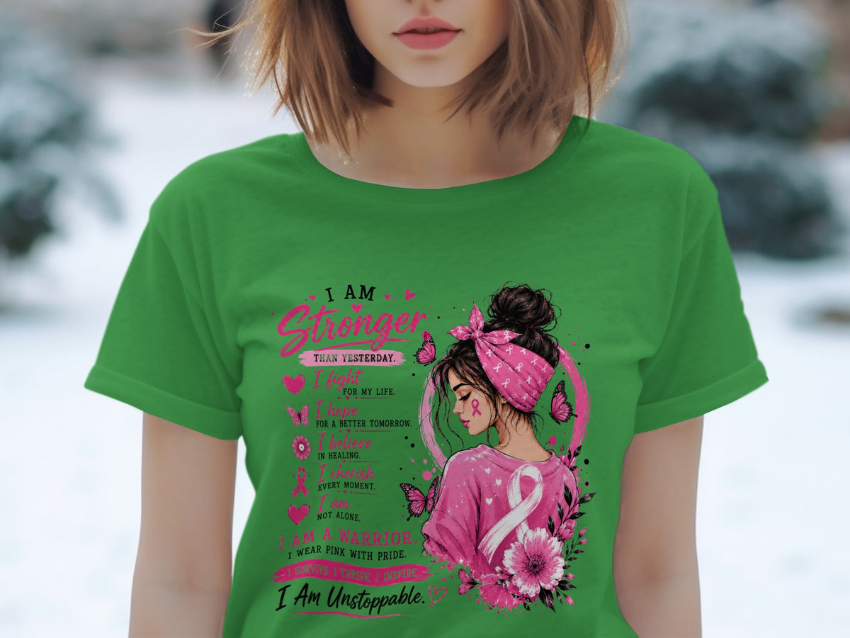 Green shirt with "I AM Stronger Than Yesterday" and breast cancer awareness imagery.