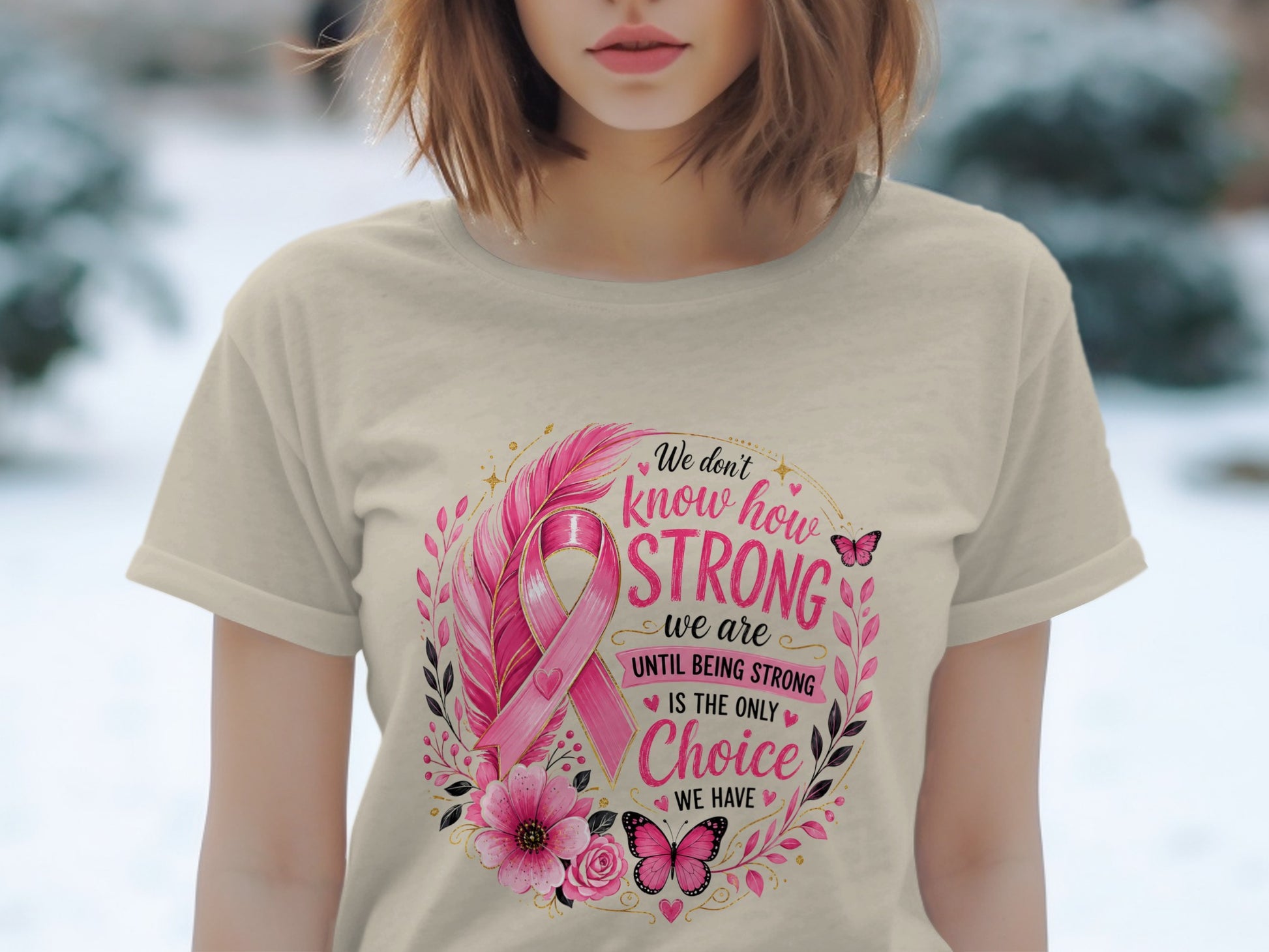T-shirt with pink ribbon, feathers, flowers, butterflies, and text "We don't know how STRONG we are UNTIL BEING STRONG IS THE ONLY Choice WE HAVE".