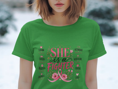 Green t-shirt with "SHE is a FIGHTER" text and pink ribbon graphic.